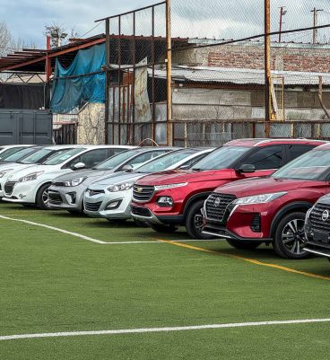 Autos Nissan, Chevrolet y Mazda en exhibición en un campo deportivo, resaltando la venta y comercialización de autos en Santiago, Chile, con enfoque en autos nuevos y usados, en un ambiente de concesionario profesional.